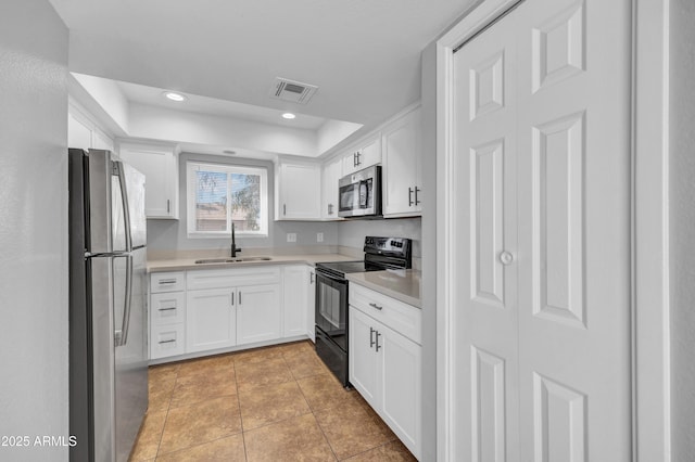 kitchen with light tile patterned floors, light countertops, visible vents, stainless steel appliances, and a sink