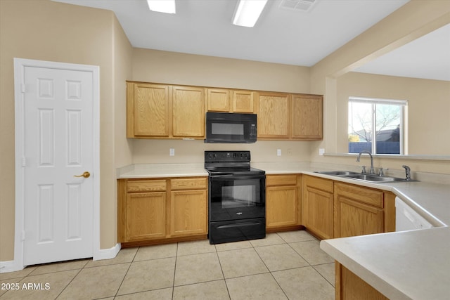 kitchen featuring light tile patterned floors, light brown cabinetry, sink, and black appliances