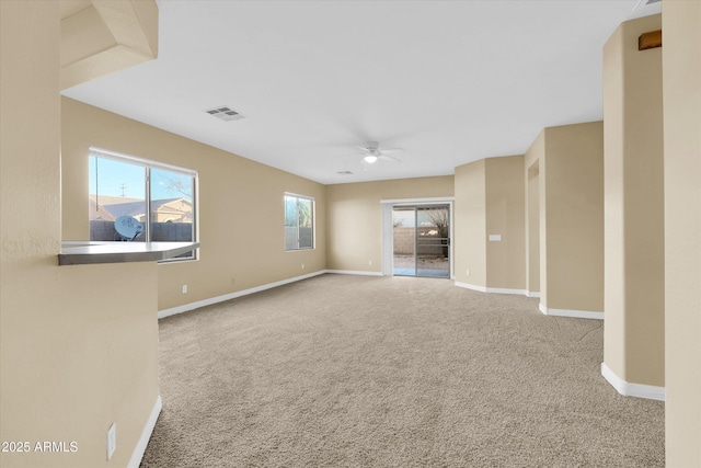 unfurnished room with plenty of natural light, carpet flooring, and ceiling fan