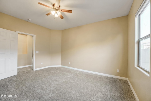 empty room featuring a wealth of natural light, ceiling fan, and carpet