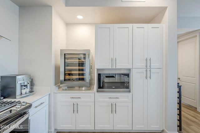 kitchen with white cabinetry, black microwave, and wine cooler