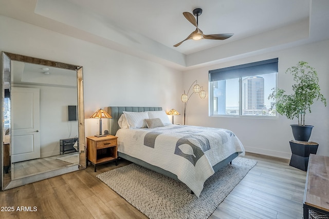 bedroom featuring hardwood / wood-style floors and a tray ceiling