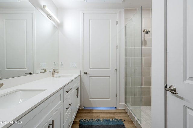 bathroom featuring vanity, hardwood / wood-style floors, and a tile shower