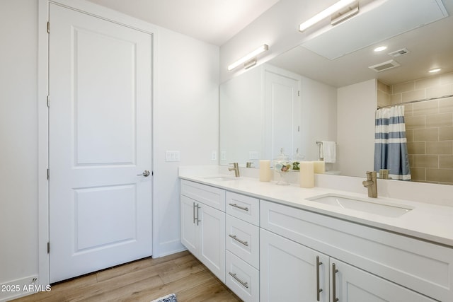 bathroom with hardwood / wood-style flooring, vanity, and walk in shower