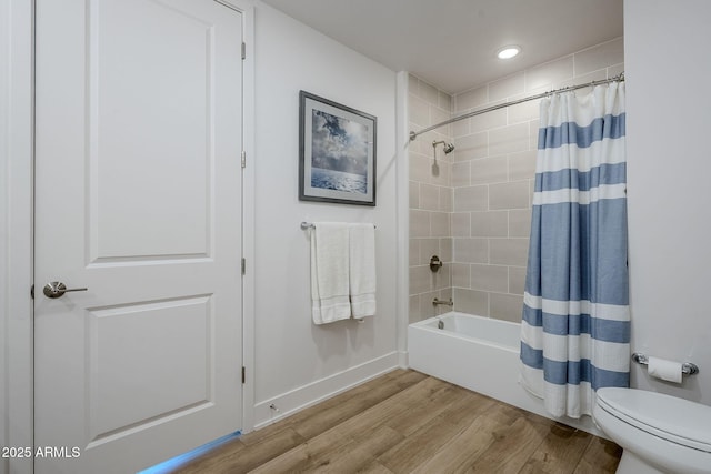 bathroom with hardwood / wood-style flooring, toilet, and shower / bath combo with shower curtain