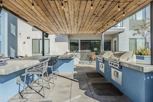 view of patio with grilling area, exterior kitchen, and an outdoor bar