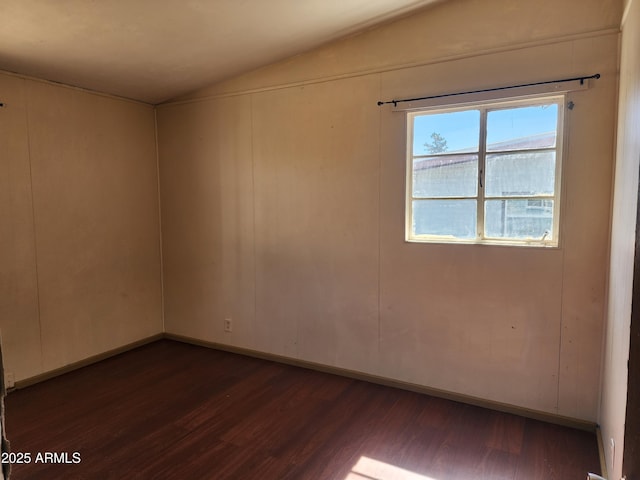 unfurnished room with dark wood-style floors and vaulted ceiling