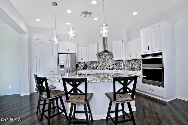 kitchen featuring backsplash, appliances with stainless steel finishes, light stone counters, dark hardwood / wood-style floors, and pendant lighting