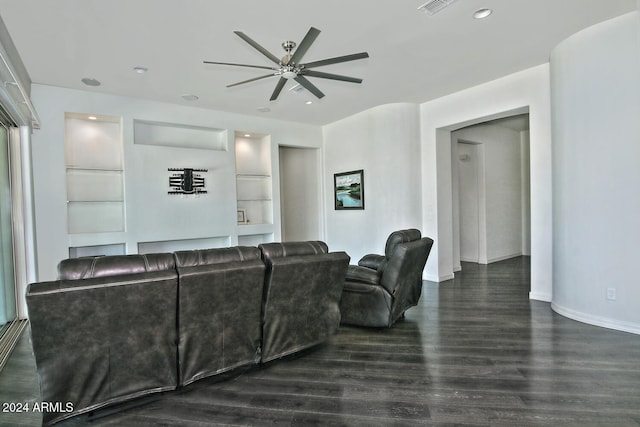 living room featuring ceiling fan, dark hardwood / wood-style floors, and built in shelves