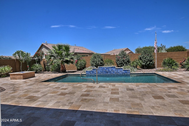 view of swimming pool with a patio and pool water feature