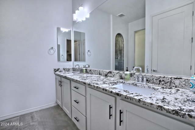 bathroom with tile patterned floors and double sink vanity