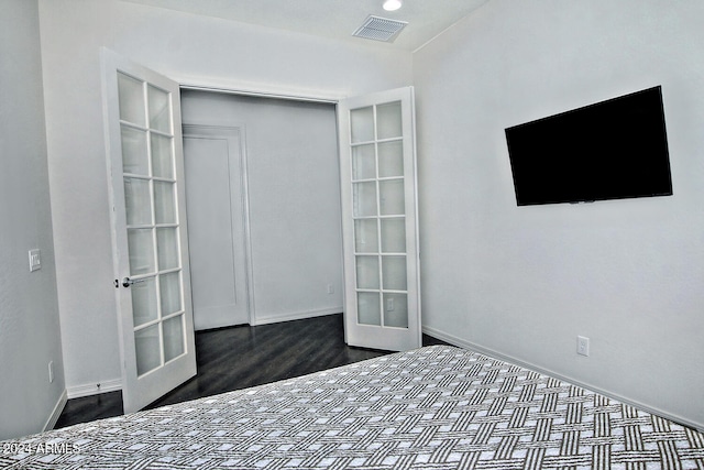 unfurnished bedroom featuring wood-type flooring and french doors