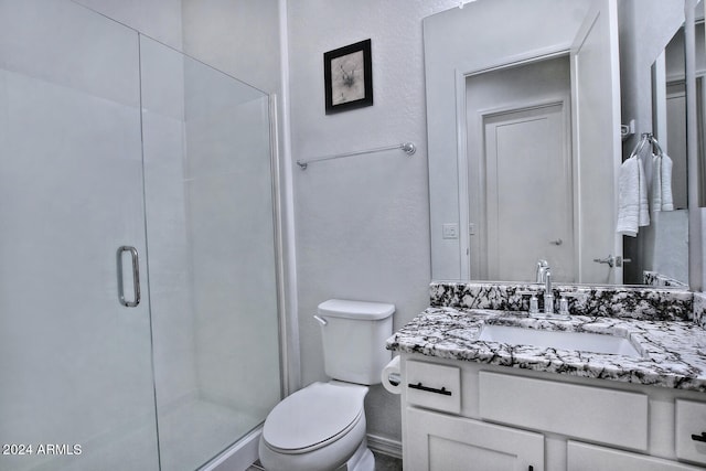 bathroom with a shower with door, toilet, and vanity