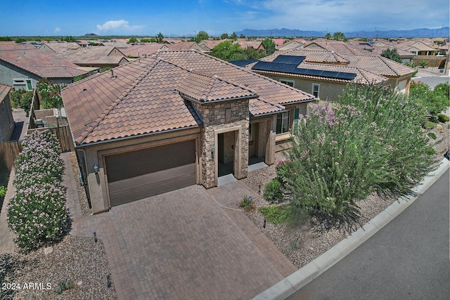 view of front of home featuring a garage and solar panels