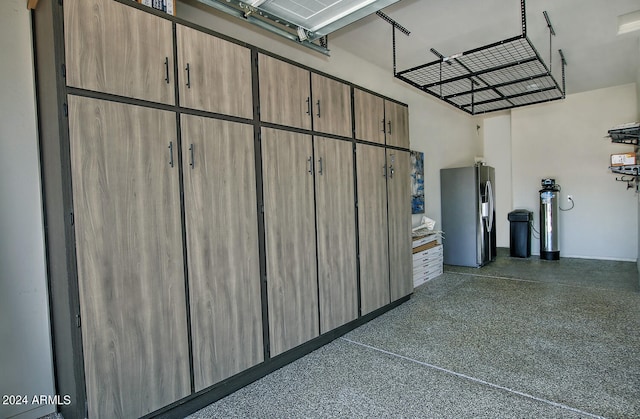 garage featuring stainless steel refrigerator with ice dispenser