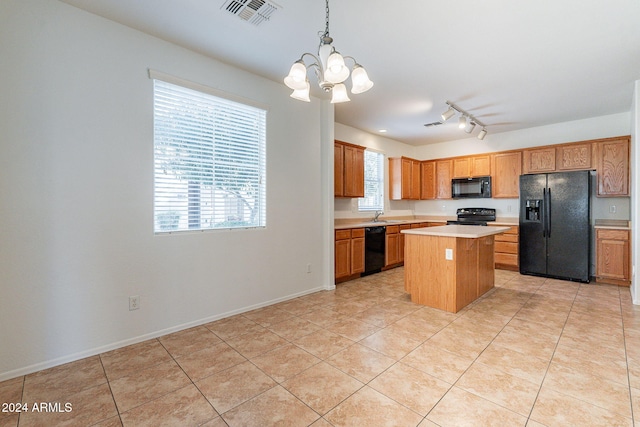 kitchen with pendant lighting, a kitchen island, plenty of natural light, and black appliances