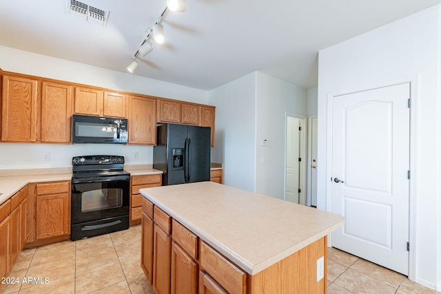 kitchen featuring light tile patterned flooring, a center island, and black appliances