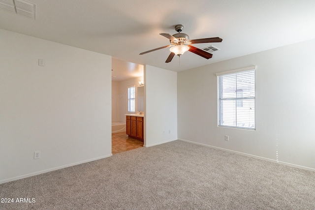 spare room with light colored carpet and ceiling fan