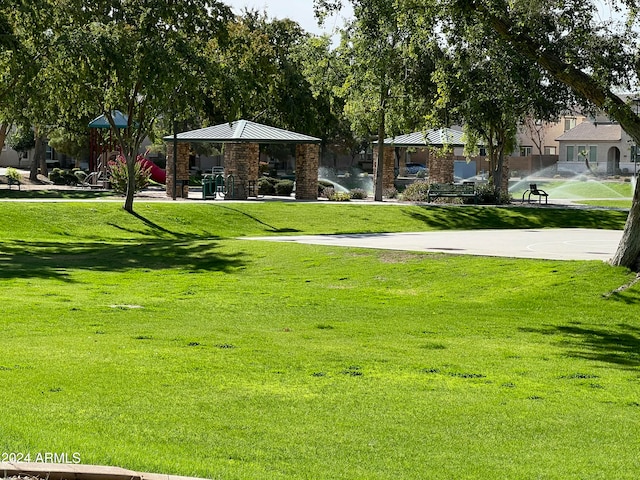 view of community featuring a gazebo, a playground, and a lawn