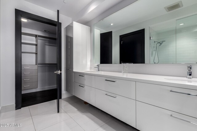 bathroom with tile patterned floors, vanity, and walk in shower