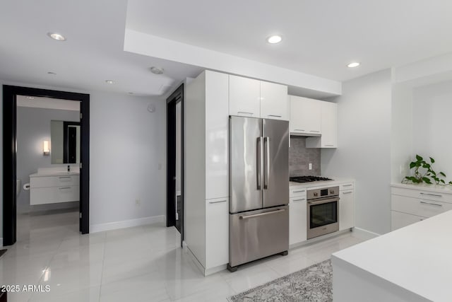 kitchen featuring white cabinetry, stainless steel appliances, and backsplash