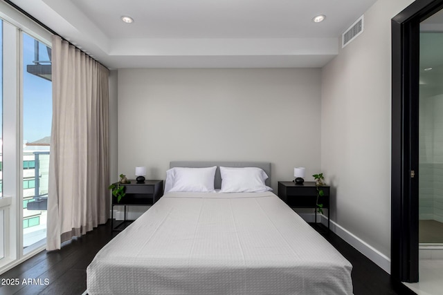 bedroom featuring multiple windows, access to exterior, and dark hardwood / wood-style flooring