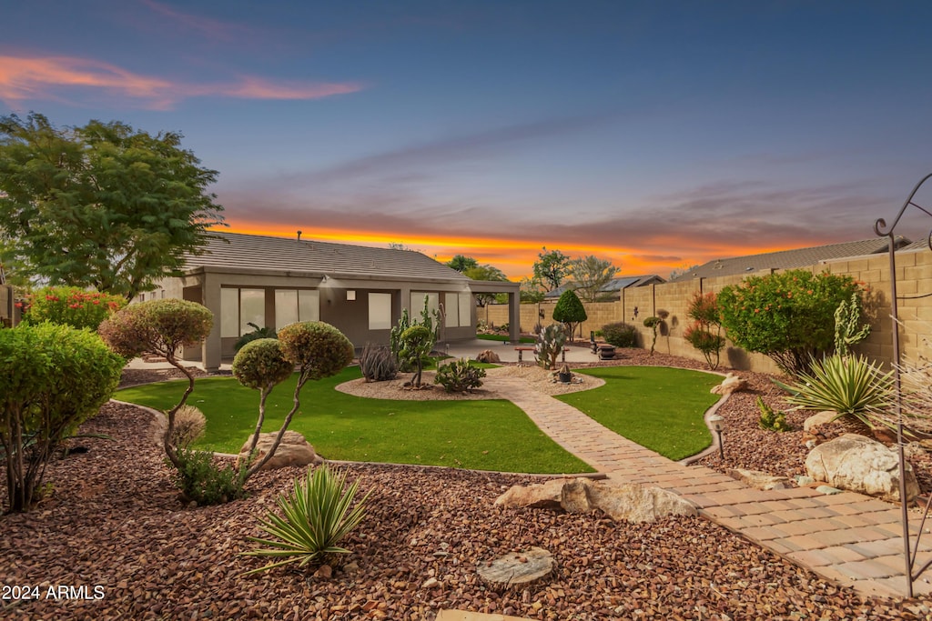 yard at dusk featuring a patio