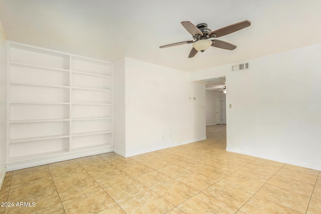 spare room featuring ceiling fan, built in features, and light tile patterned floors