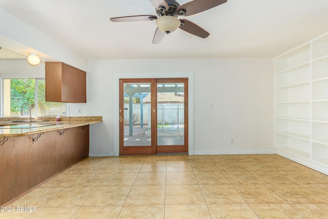 kitchen featuring ceiling fan, french doors, sink, built in features, and light tile patterned flooring