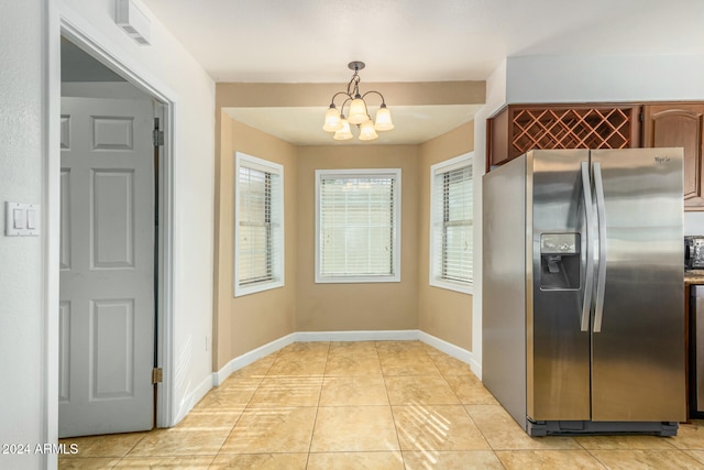 kitchen with decorative light fixtures, stainless steel fridge, light tile patterned floors, and a chandelier