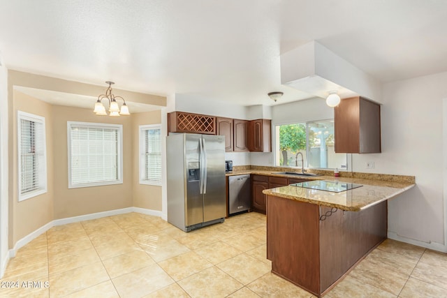 kitchen featuring kitchen peninsula, appliances with stainless steel finishes, sink, a chandelier, and hanging light fixtures