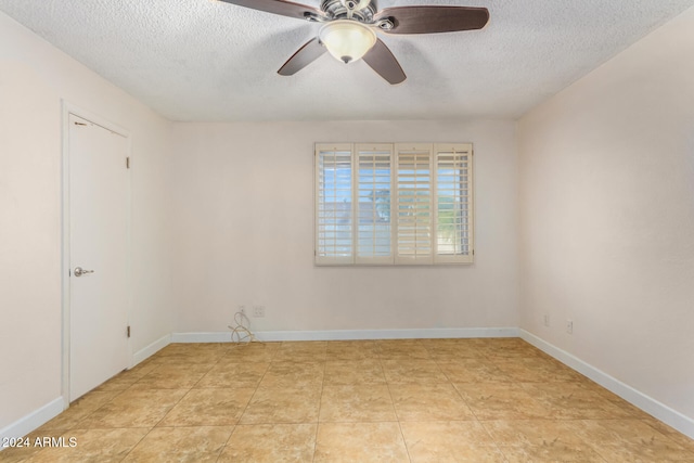 spare room with ceiling fan, light tile patterned floors, and a textured ceiling