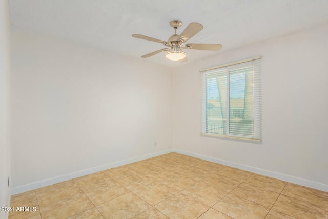 tiled spare room featuring ceiling fan