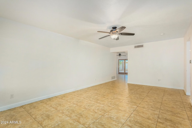 tiled empty room featuring ceiling fan