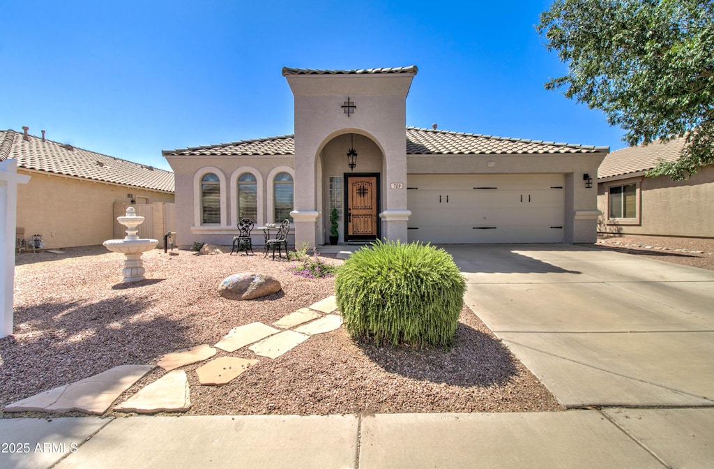 709 E Dry Creek Rd, San Tan Valley, AZ 85143 - mediterranean / spanish home featuring an attached garage, stucco siding, a tile roof, and driveway