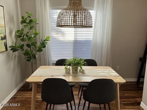 dining space featuring baseboards and wood finished floors