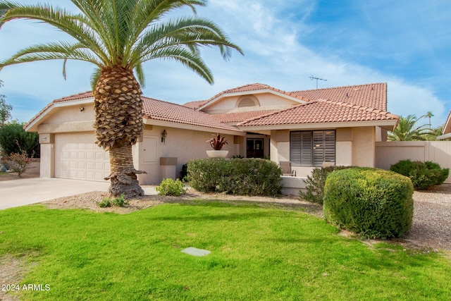 mediterranean / spanish-style home with a front lawn and a garage