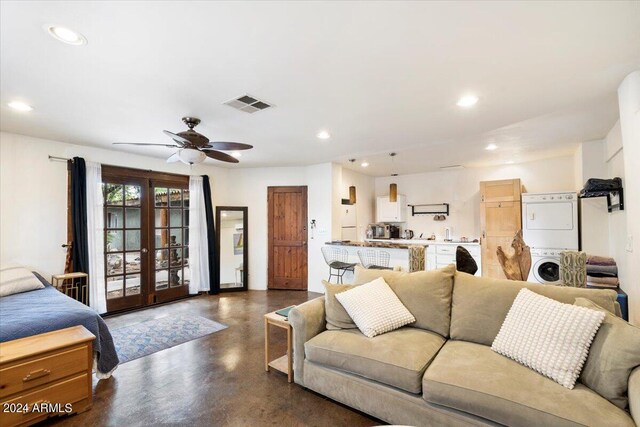 living room with stacked washing maching and dryer, ceiling fan, and french doors