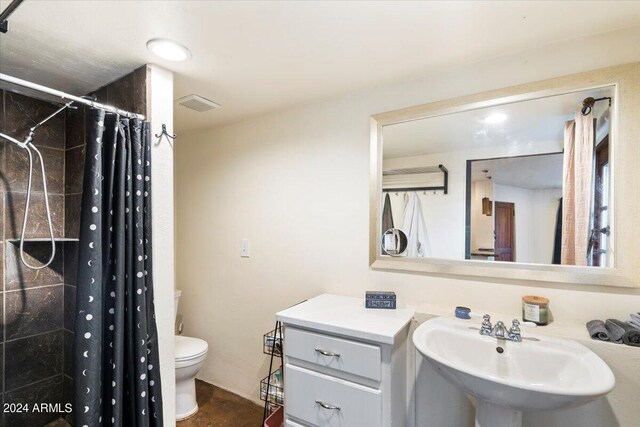 bathroom with a shower with curtain, sink, and toilet