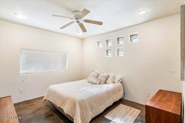 bedroom with ceiling fan and dark colored carpet