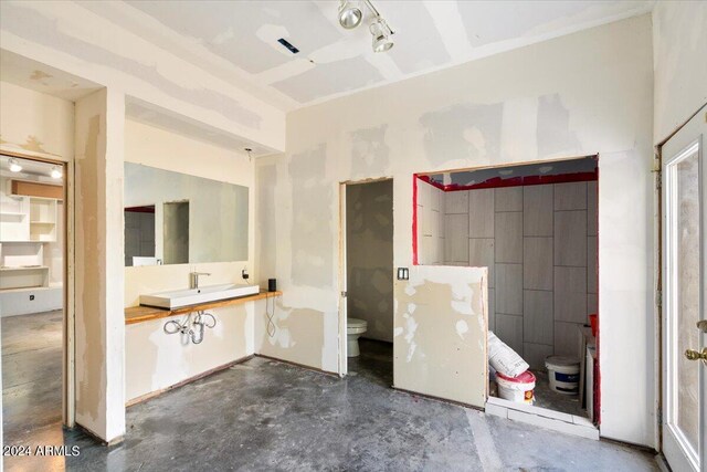 bathroom featuring concrete flooring, sink, and toilet