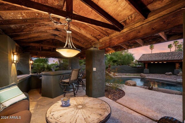 patio terrace at dusk featuring a bar