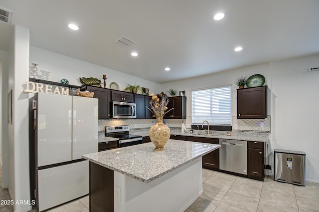 kitchen featuring dark brown cabinets, appliances with stainless steel finishes, a sink, and visible vents