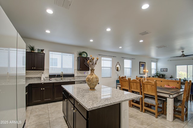 kitchen with tasteful backsplash, refrigerator, visible vents, and a sink