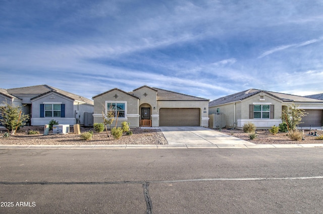 view of front of home with an attached garage, central air condition unit, concrete driveway, and stucco siding