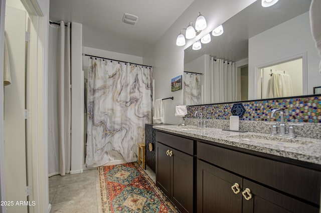 bathroom with double vanity, tile patterned flooring, visible vents, and a sink