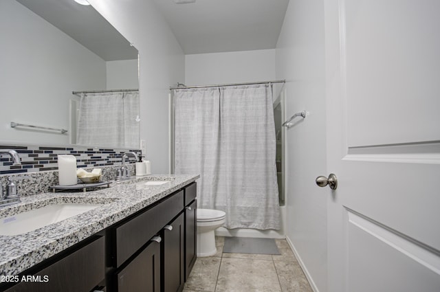 full bathroom with double vanity, tasteful backsplash, a sink, and toilet