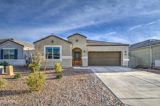 mediterranean / spanish-style home with a garage, driveway, a tiled roof, and stucco siding