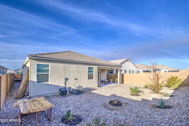 back of property featuring a fenced backyard, a tiled roof, a patio, and stucco siding