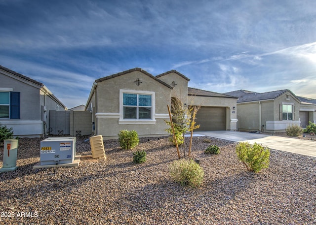 view of front of house featuring a garage, a tiled roof, concrete driveway, and stucco siding